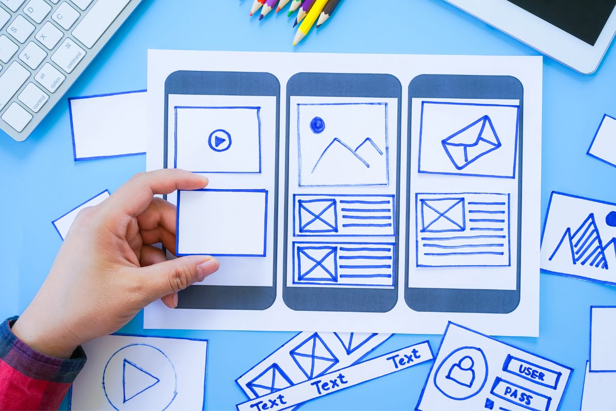 A person is pointing at a paper with a design on it, emphasizing the importance of web content accessibility.