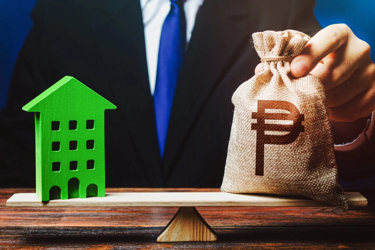 A businessman holding a bag with a house on a sustainable scale.