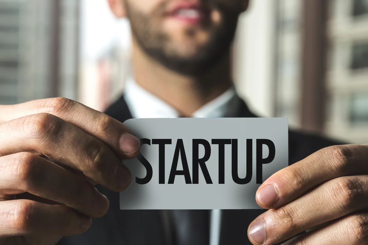Digital Marketing Agencies For Startups: Unleashing Growth And Success 4 A man holding up a business card with the word startup.