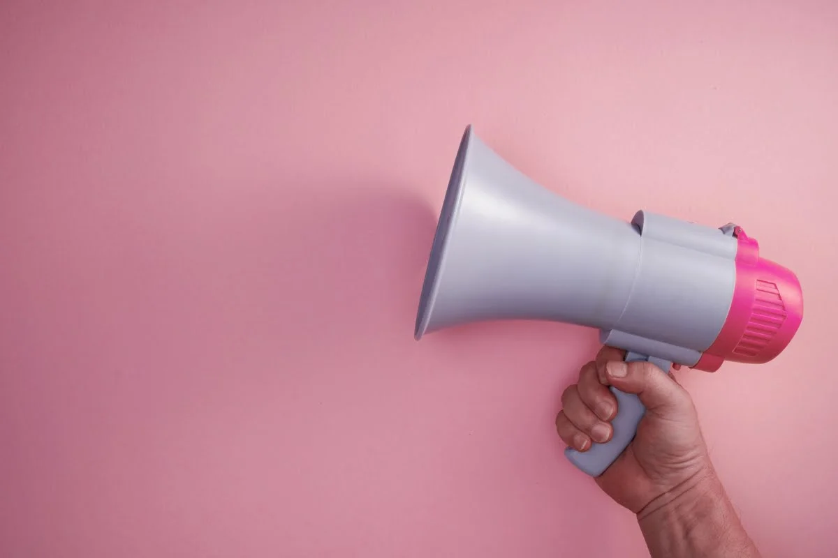Maximize Your Reach with HVAC Local Service Ads 10 A hand holding a megaphone promoting local HVAC service ads on a pink background.