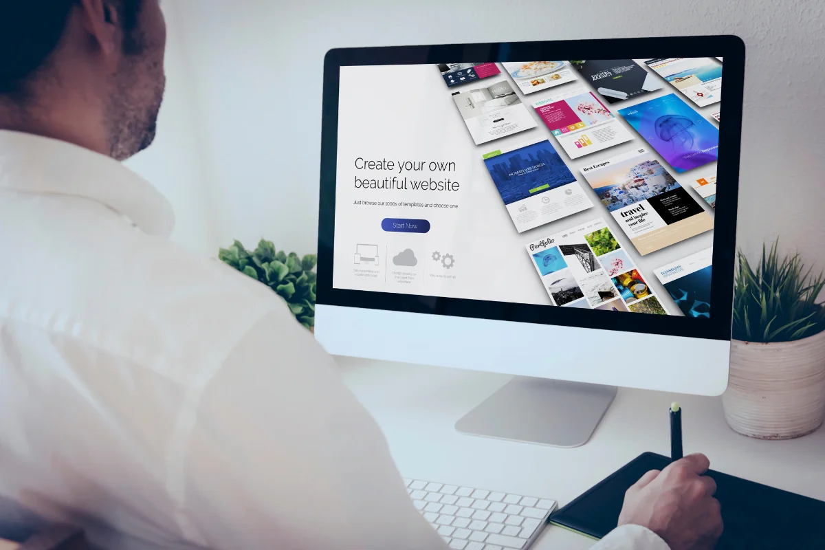 What Are WordPress Themes And How They Transform Websites 5 A man sitting at a desk looking at a computer screen, researching WordPress themes.