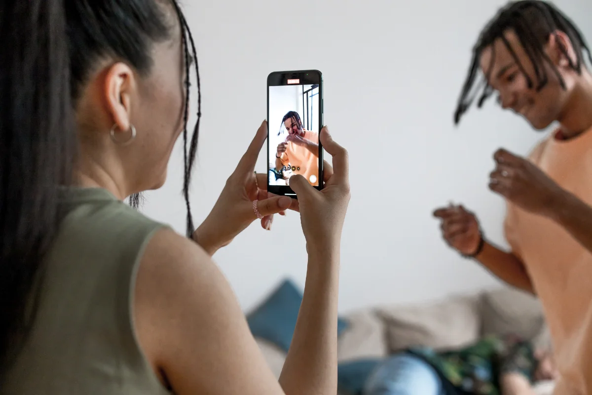 Short Video Content Strategy: Compelling Clips for Maximum Engagement 5 A woman recording a man dancing as part of her short video content strategy.