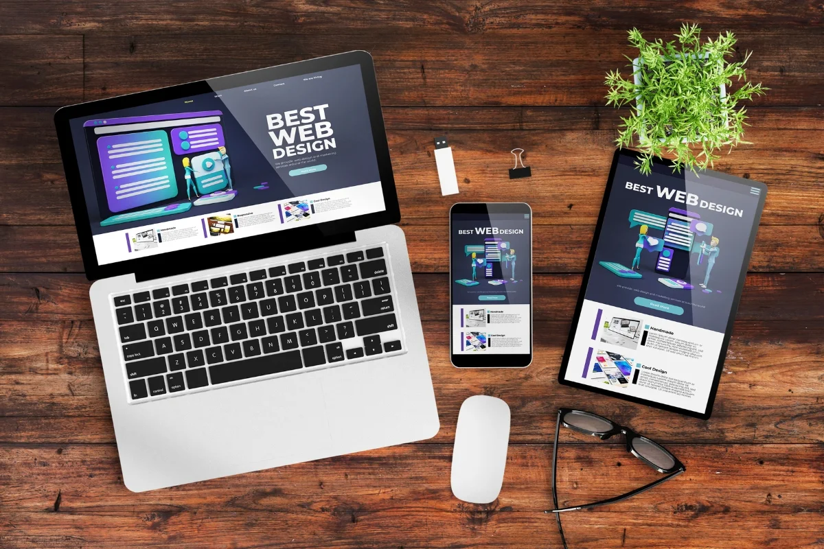 Website Header and Footer: Crafting the Perfect User Experience 6 A laptop, phone, tablet and plant on a wooden table suitable for a website header.