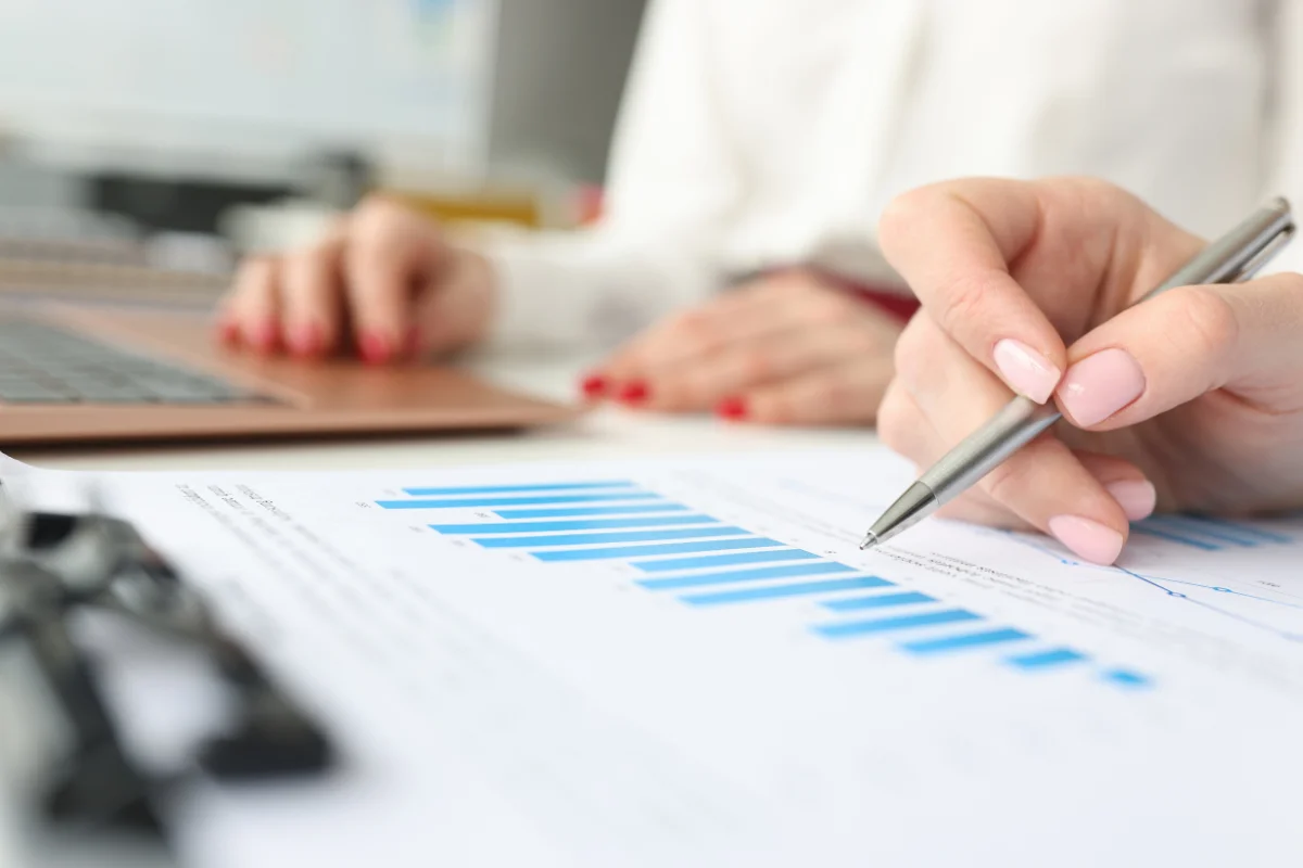 We Write Blog Posts: Crafting Compelling Content For Success 5 A woman is reviewing data on a piece of paper with a pen.