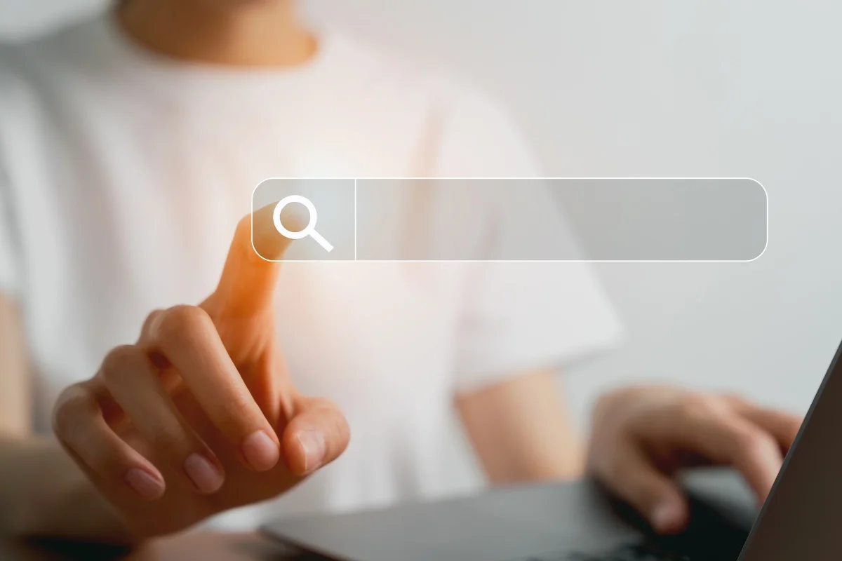 How to Search on a Website: Mastering the Art of Navigation 9 Person using a laptop and clicking on a digital search bar projected in front of them to learn how to search on a website.