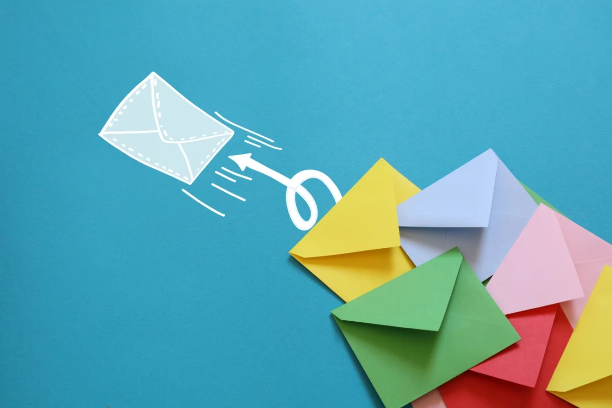 Email Marketing for Plumbers: Boost Your Plumbing Business Effectively 5 Colorful envelopes are spread out on a blue background with a drawing of a white envelope and an arrow pointing upward, symbolizing the rise of email marketing for plumbers.