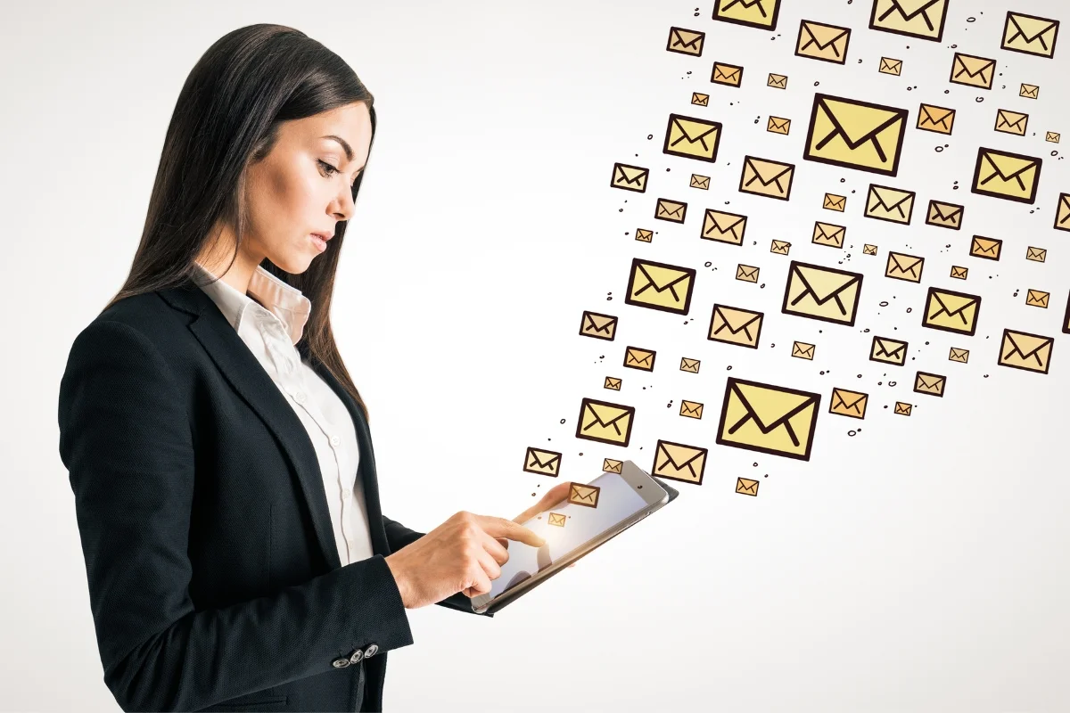 Email Marketing for Plumbers: Boost Your Plumbing Business Effectively 7 A woman in a suit operates a tablet with numerous digital mail icons emanating from it, symbolizing email marketing for plumbers.