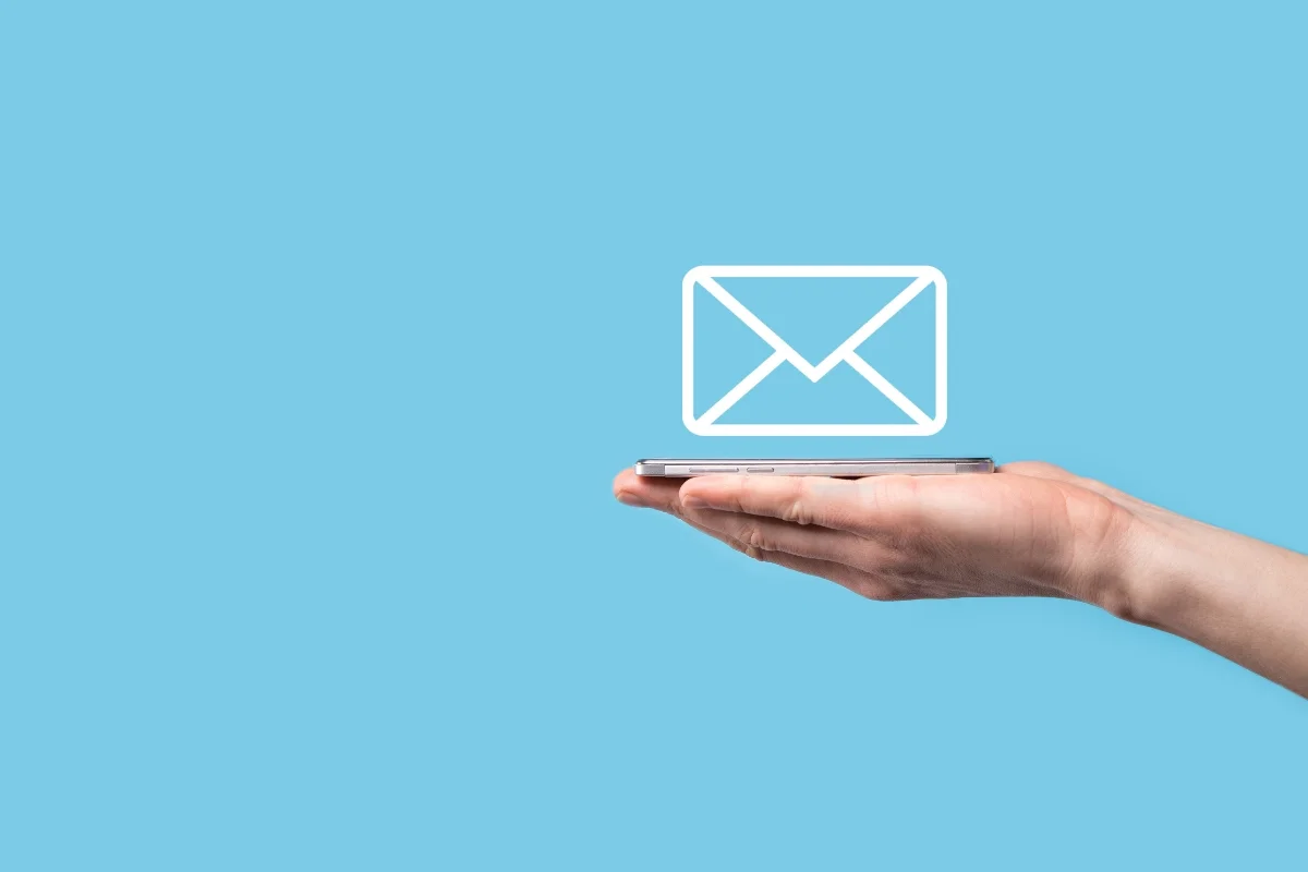 Email Targeting: Master the Art of Personalized Messaging 9 A hand holds a smartphone against a blue background. A white envelope icon, symbolizing email targeting, floats above the phone.