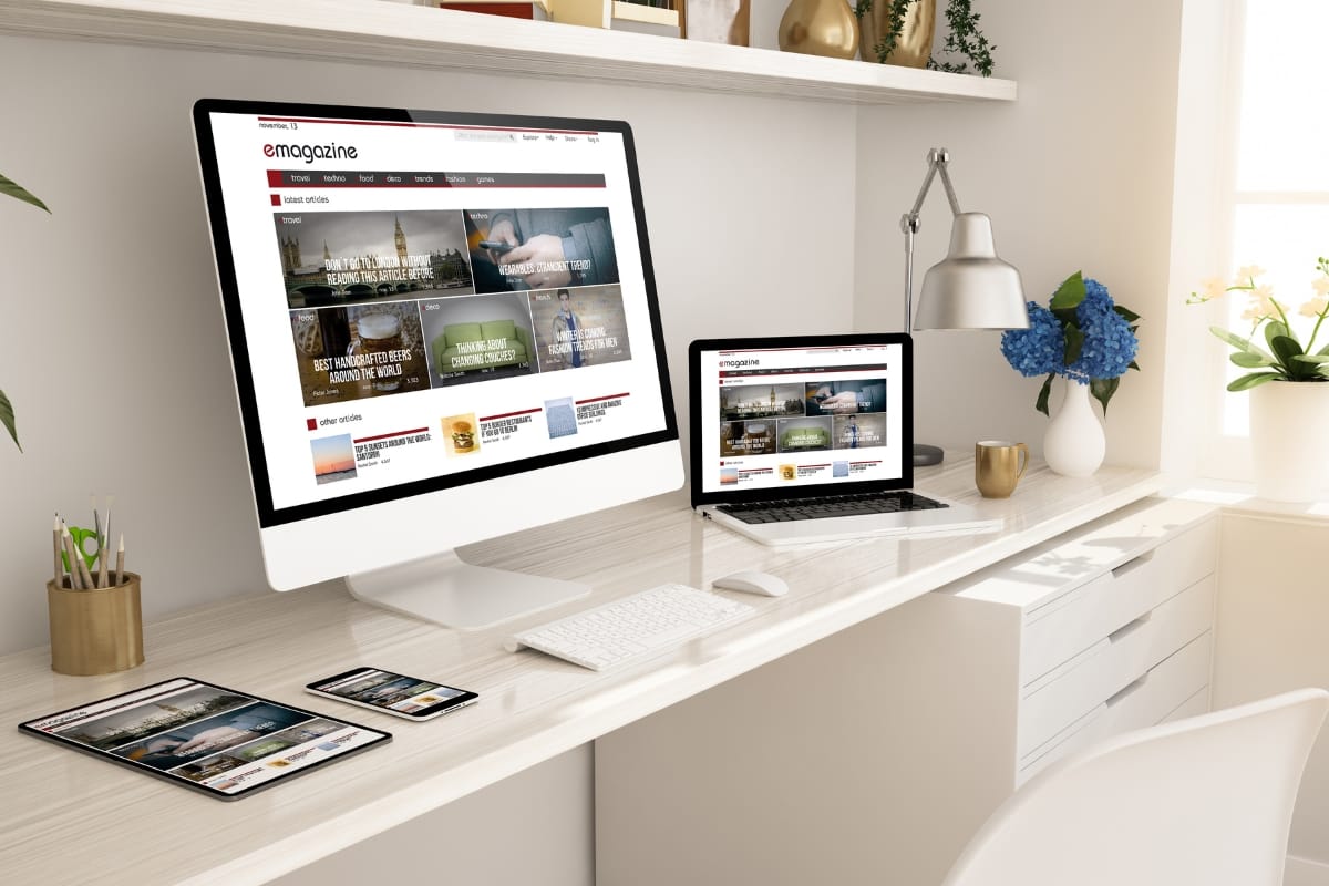 Must-Have Database Maintenance Plugins for WordPress 12 A workspace featuring a large monitor, laptop, tablet, and smartphone displaying a website for database maintenance. The desk is neatly arranged with a keyboard, mouse, lamp, books, and a plant in a vase.