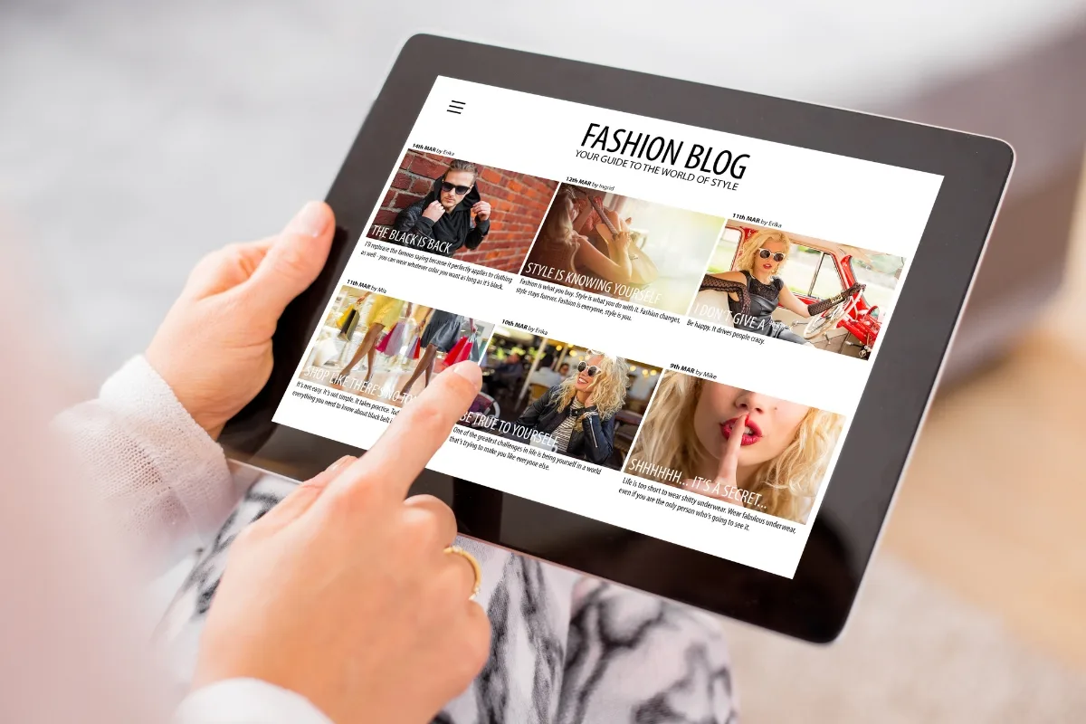 Enhance Your WordPress Site by Mastering Engaging Content Creation 4 A person holds a tablet displaying a fashion blog brimming with engaging content creation, featuring photo articles on style trends and accessories.