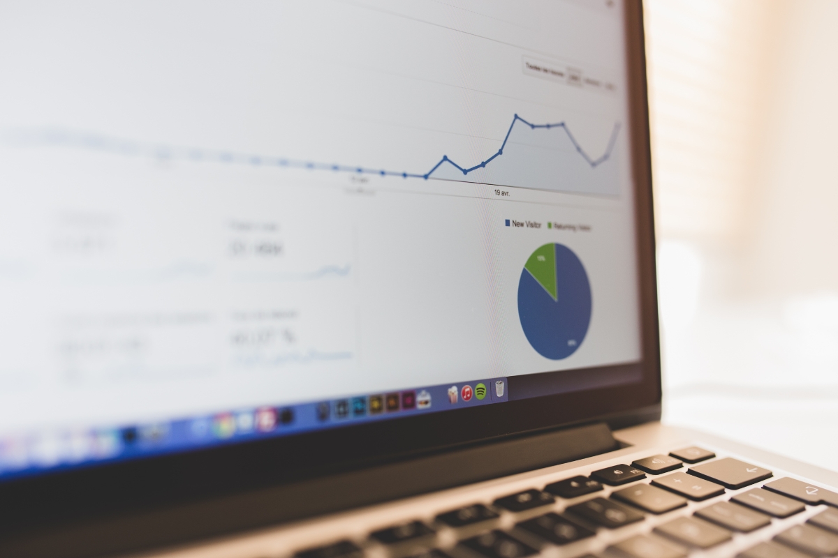Understanding Google's Core Web Vitals and Its Impact on SEO 6 A laptop displaying a screen with data analytics, including a line graph, a pie chart, and various data points related to core web vitals.