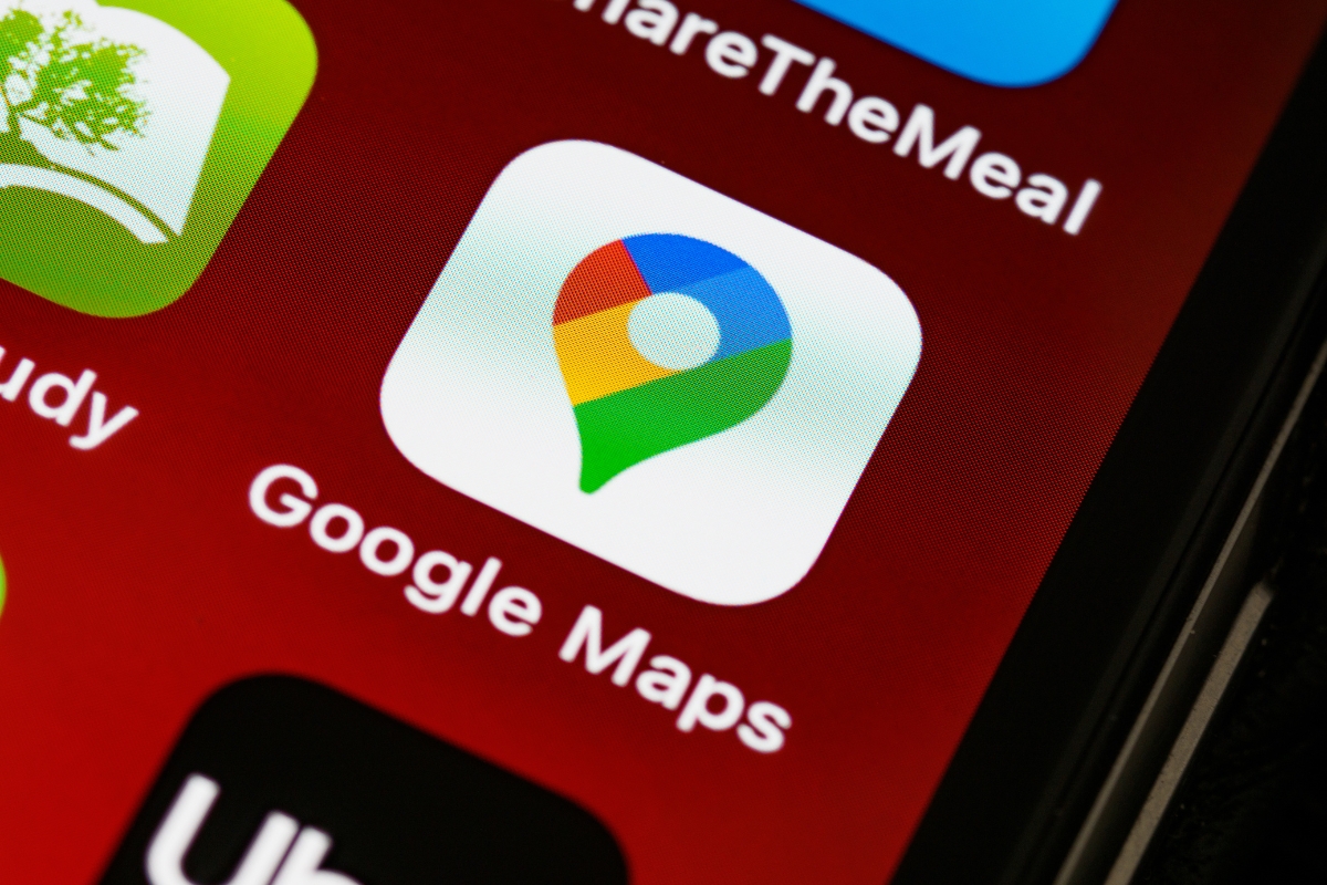 Optimizing for 'Near Me' Searches: A Guide for Local Businesses 4 A close-up of a smartphone screen displaying the Google Maps app icon, often used for 'near me' searches, with its name below and surrounded by other app icons on a red background.