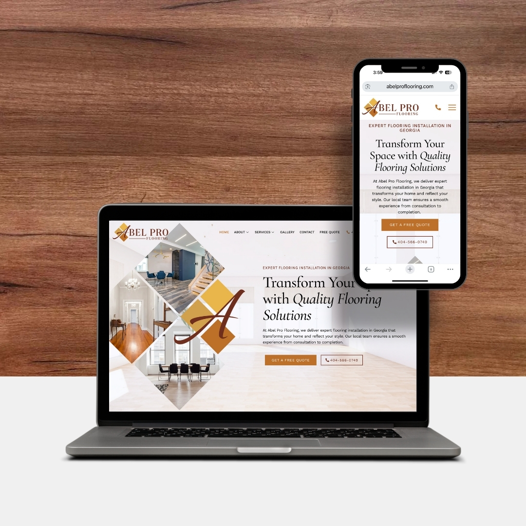 A laptop and smartphone display the Abel Pro Flooring website, with both devices placed on a light surface against a wooden wall background.