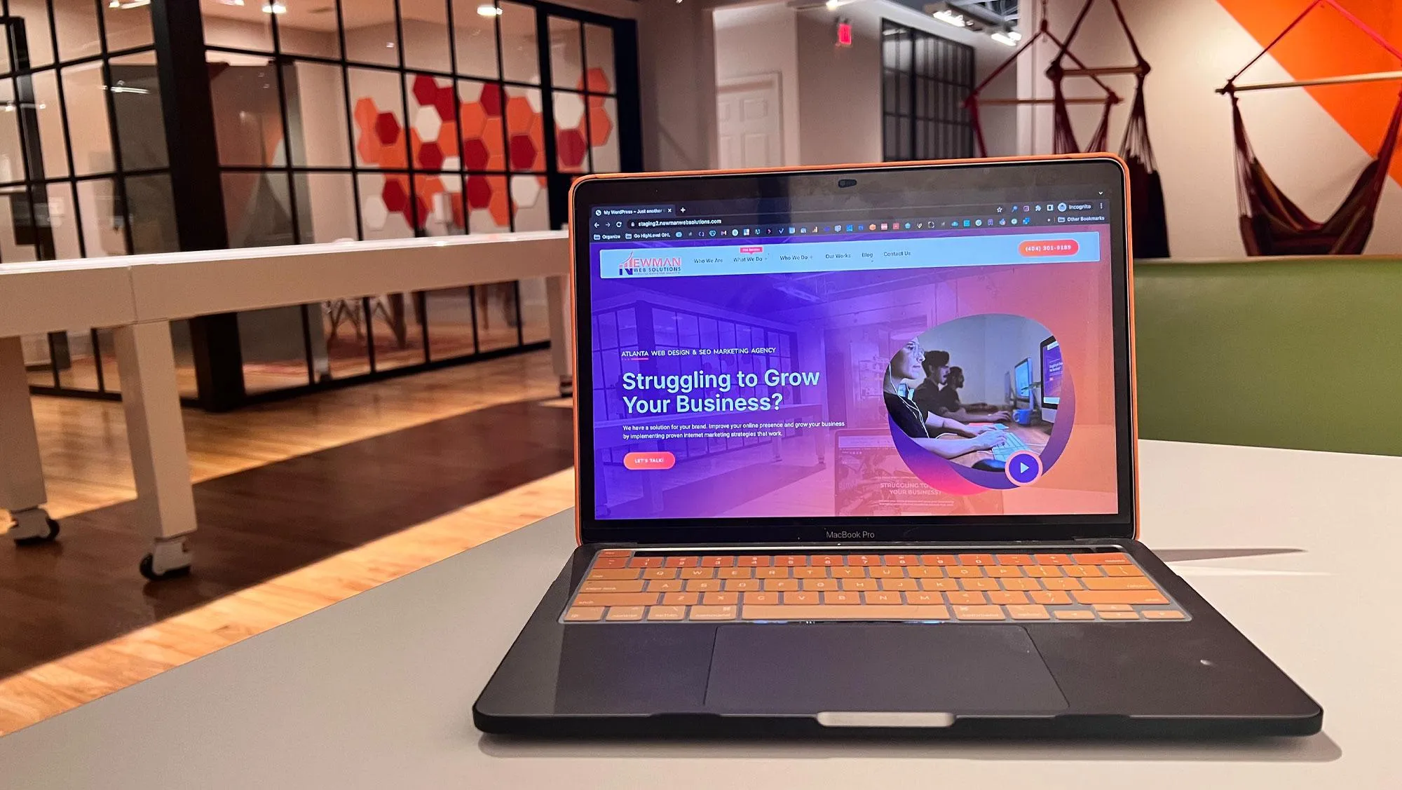 Laptop displaying a business growth website in a modern office setting.